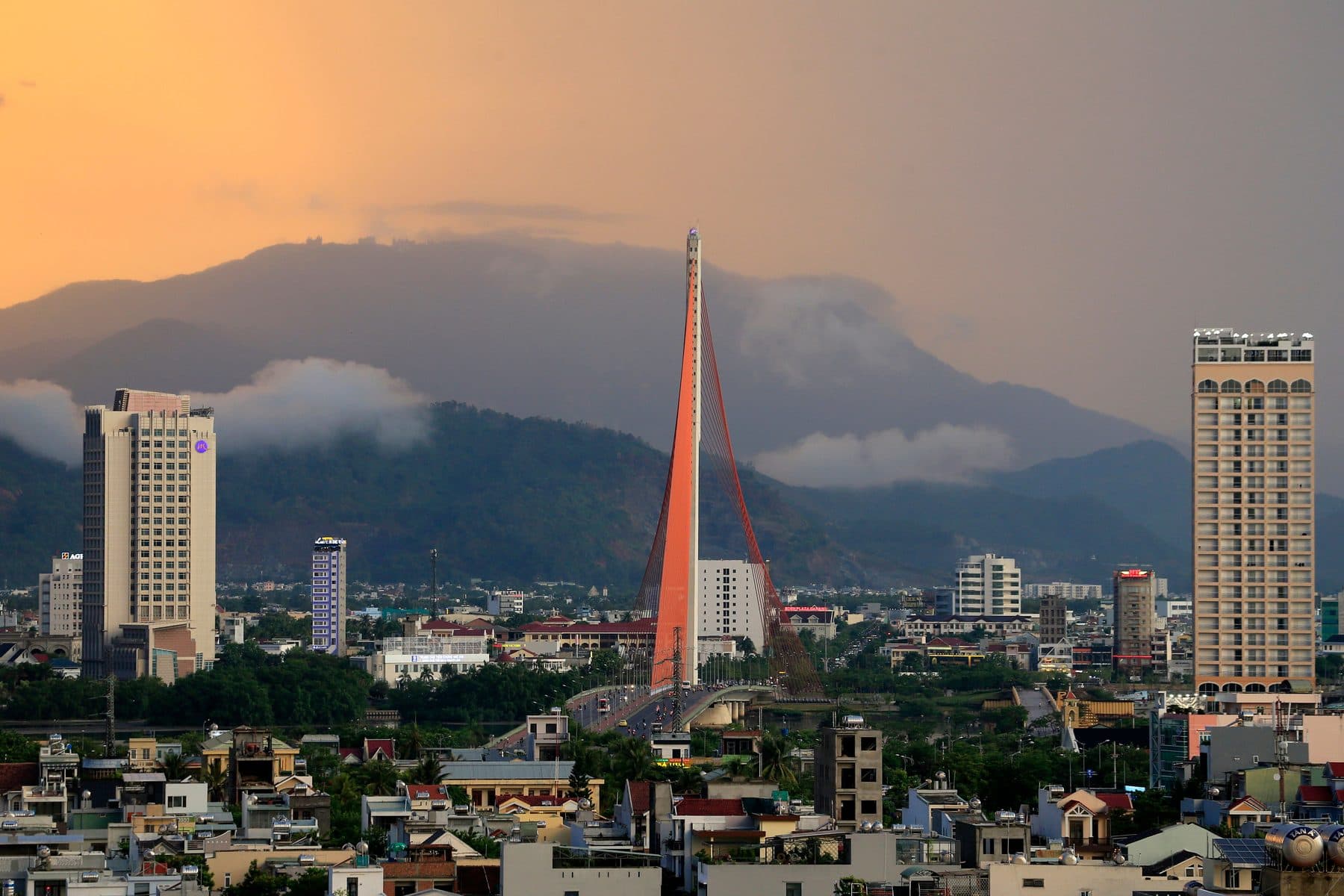 Da Nang at dusk, the Tran Thi Ly bridge pylon and the mountain behind under cloud