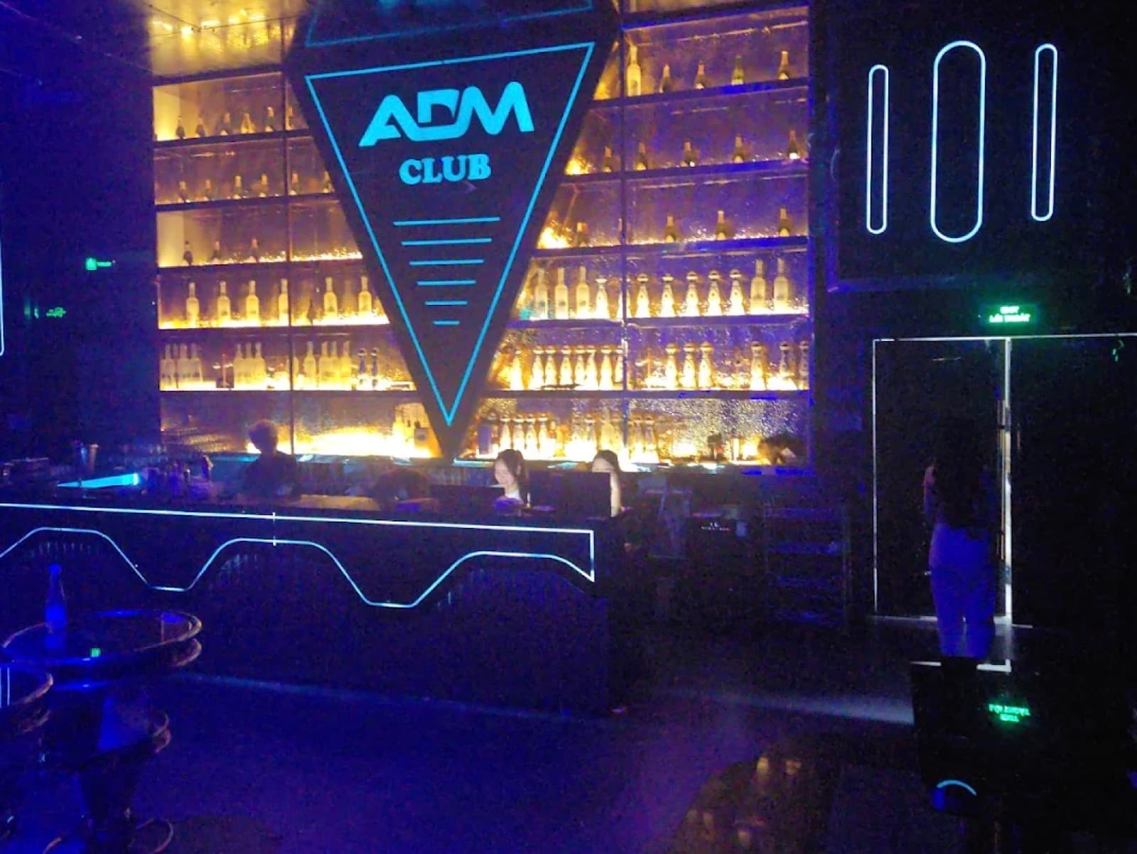 The bar at ADM Club under a blue neon sign