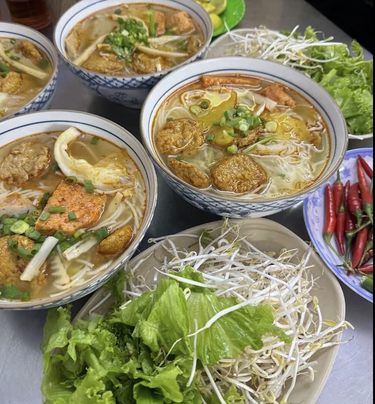 Bowls of bun cha ca with fresh greens and chili at Bún Chả Cá 109