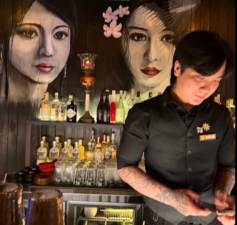 C Bar, a bartender at the counter in front of the painted faces