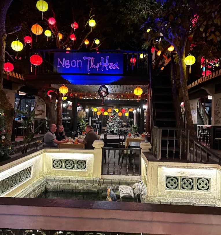 C Bar, the way in through the garden, with lanterns above the tables and a pond