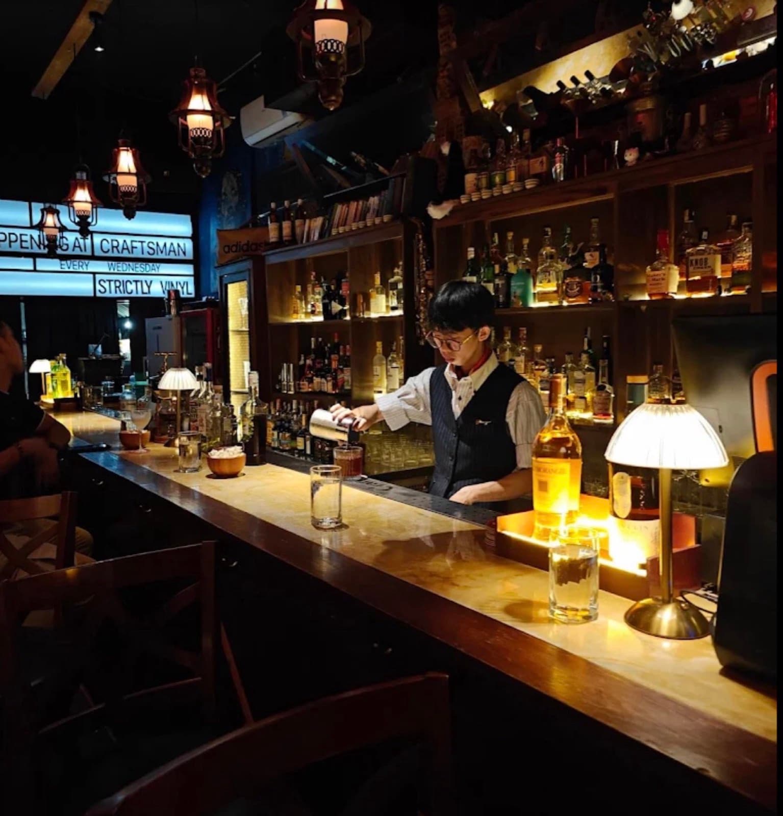 The Craftsman, the candlelit bar with the bartender at work