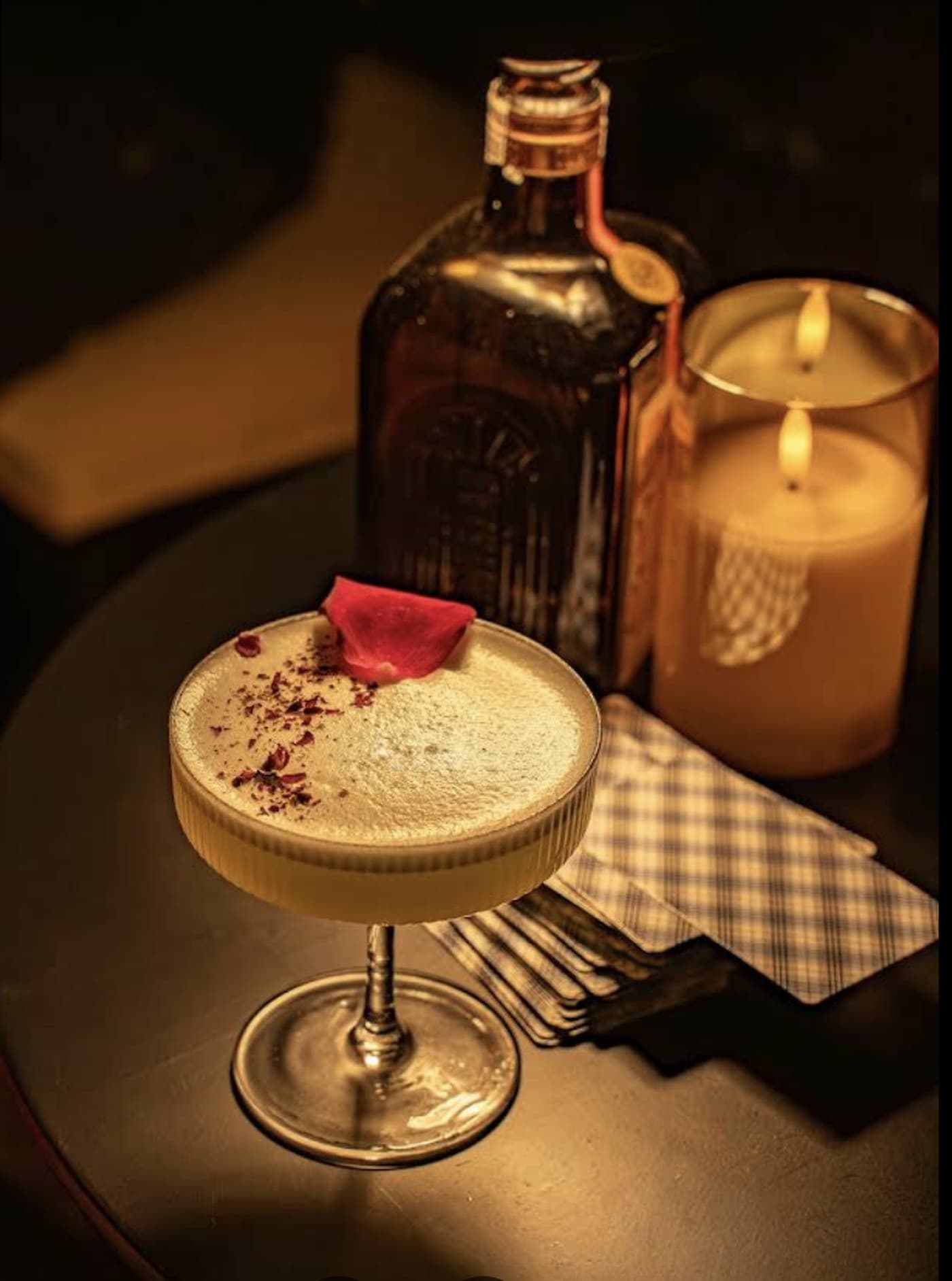ĐÊM Speakeasy, a coupe beside a candle