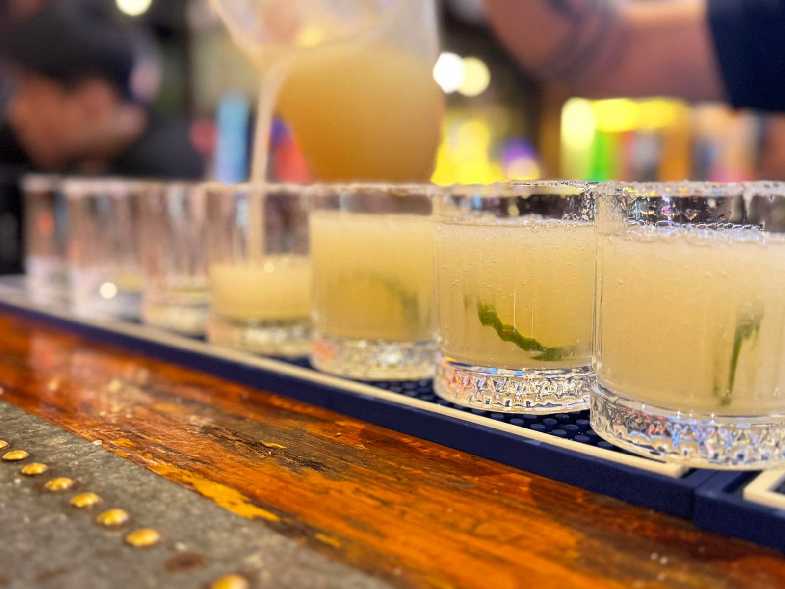 A row of margaritas with salted rims along the bar rail at Dirty Fingers in Da Nang