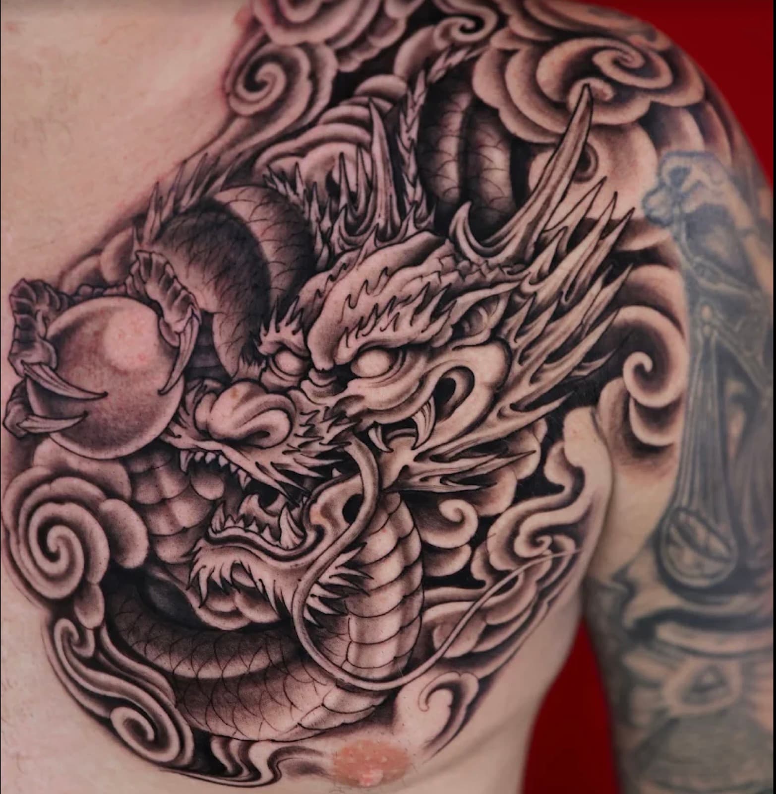 A black and grey dragon chest piece tattooed at Dragon City Ink
