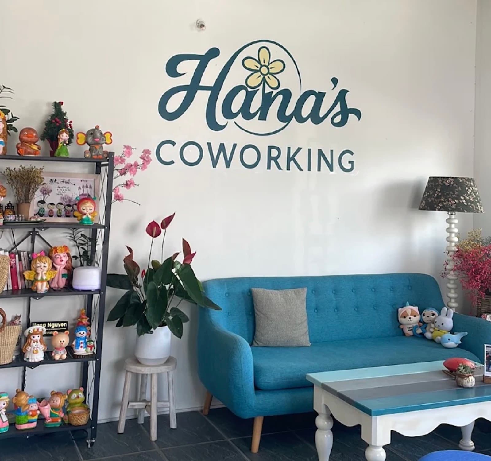 The hand painted Hana's Coworking wordmark above the blue sofa in the front room
