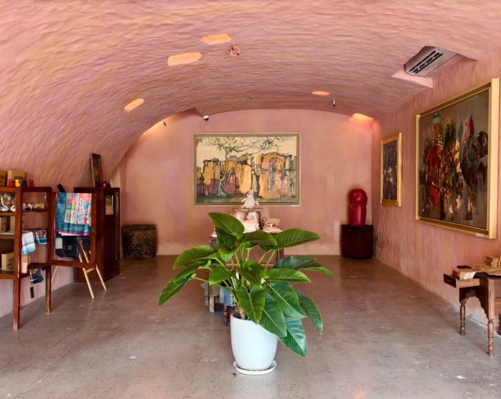 Paintings and sculpture under a curved clay vault at The Hangart