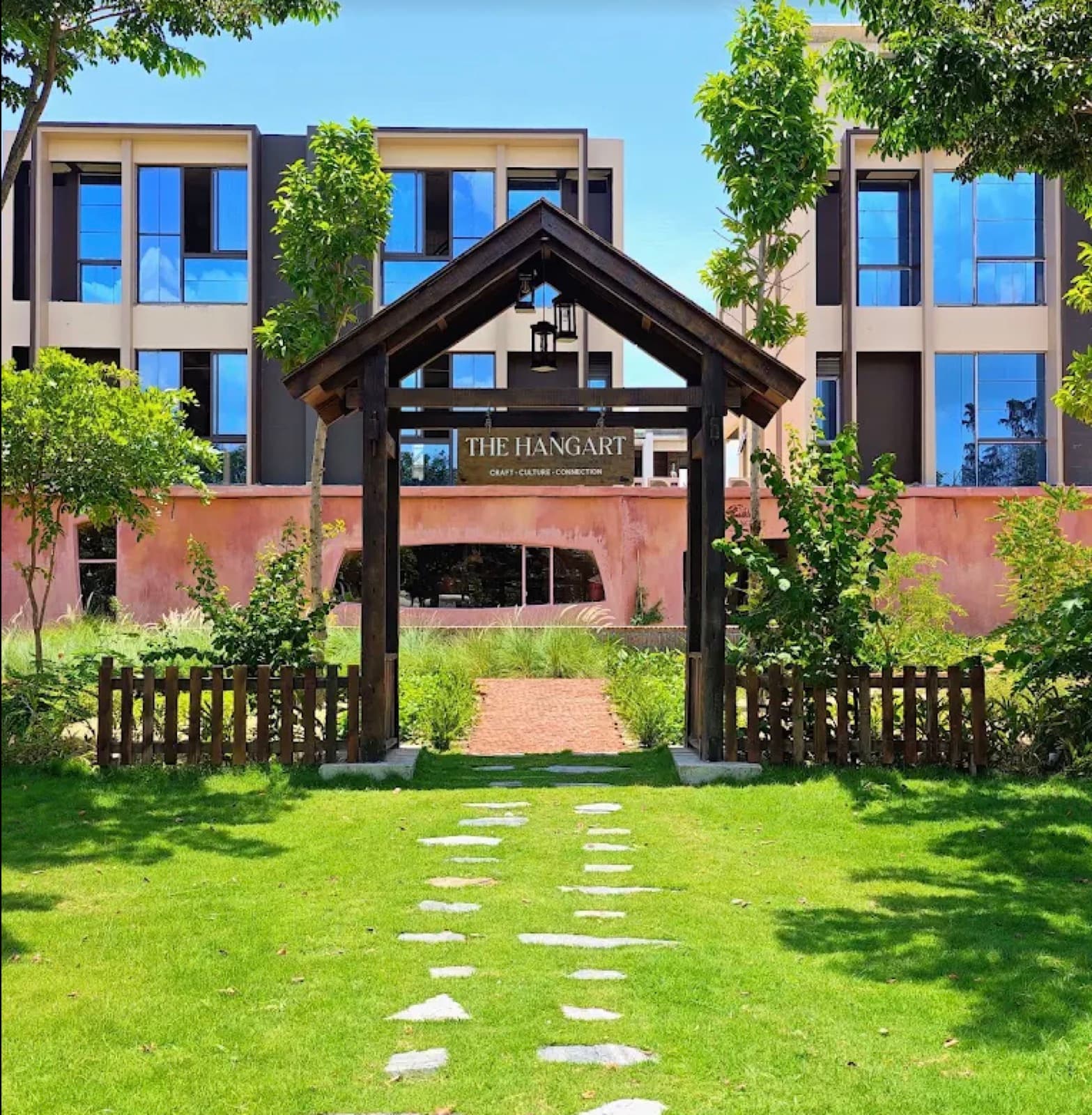 The wooden gate and lawn at the entrance to The Hangart in Da Nang