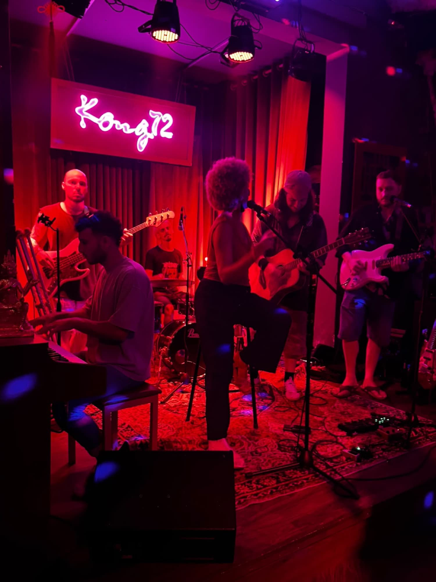 Kong 72 Speakeasy Bar, ban nhạc chơi trên sân khấu dưới bảng đèn neon hồng