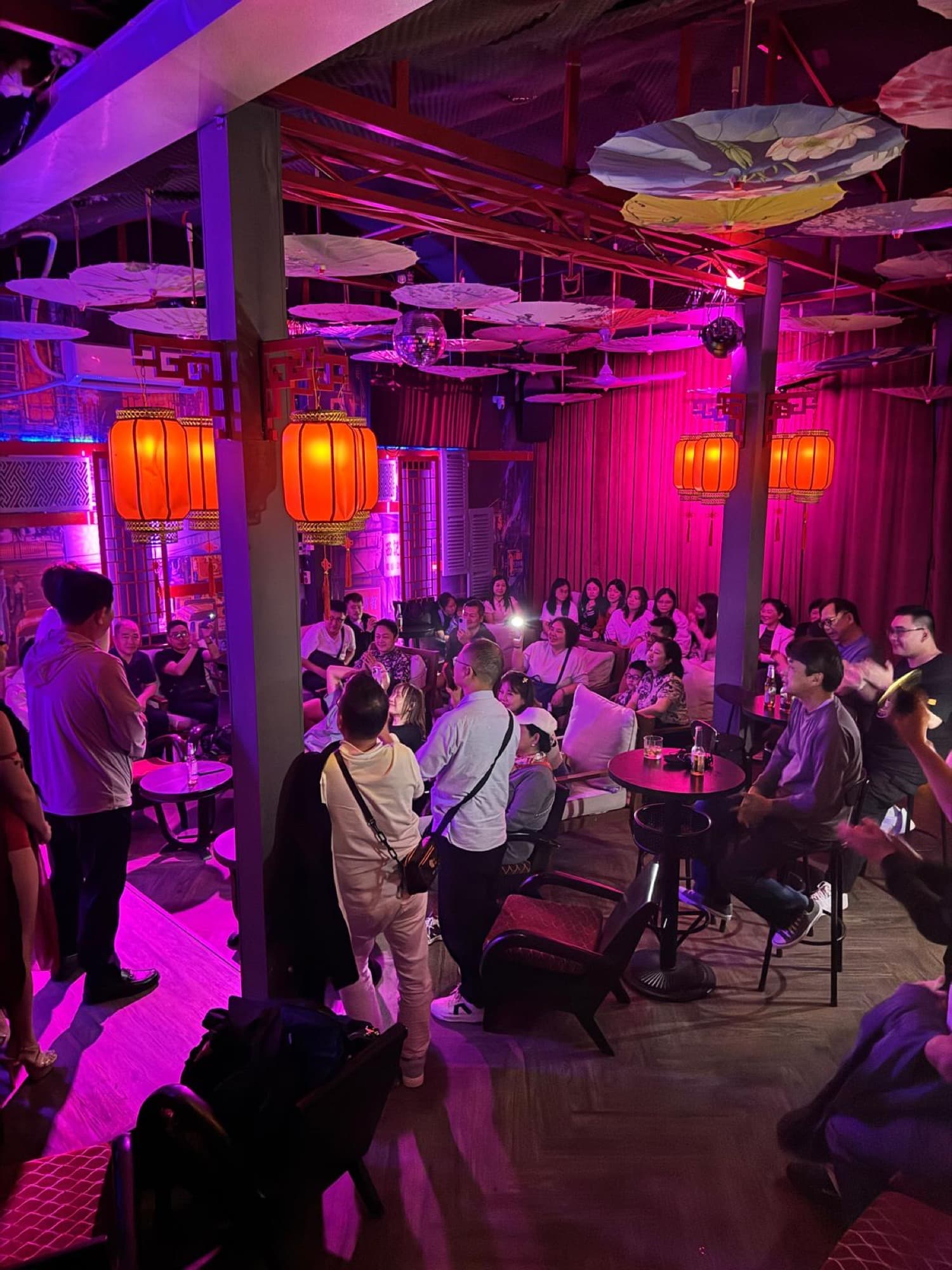 Kong 72 Speakeasy Bar, hai người biểu diễn trên sân khấu dưới bảng đèn neon hồng