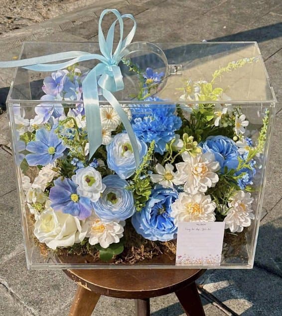 A blue and white flower box set in a clear case from Mér Florist