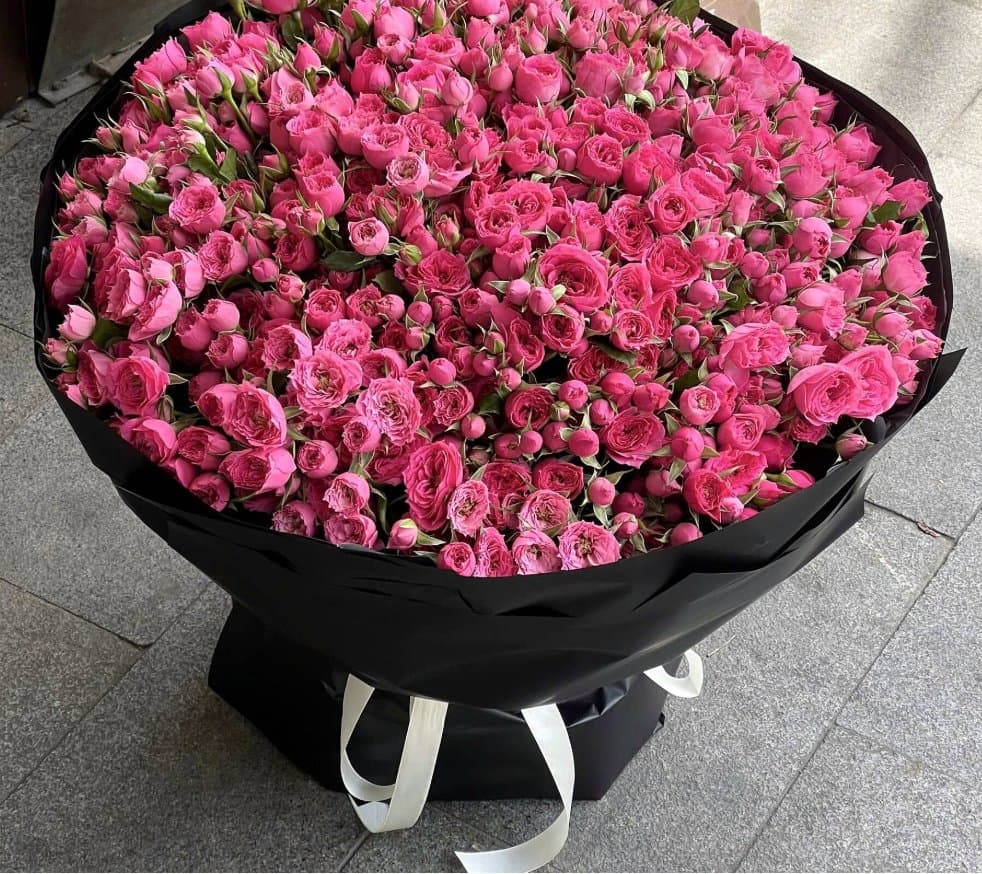 A large pink rose bouquet by the shop front at Mér Florist