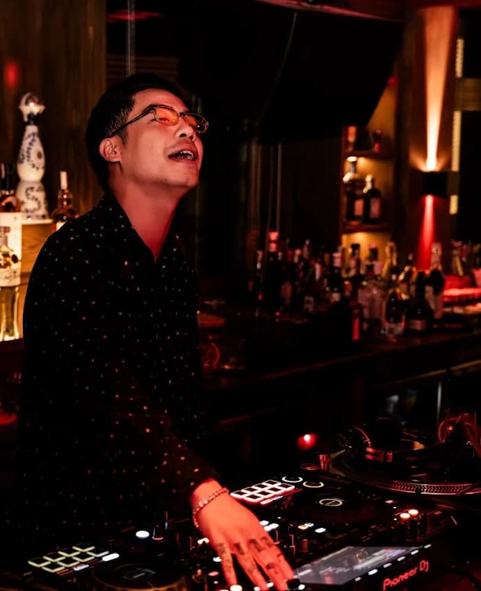 A DJ sings at the decks at Midnight Condo