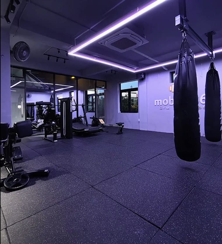 mobifit360 Gym & Fitness, bao đấm treo trên sàn tập dưới ánh đèn tím