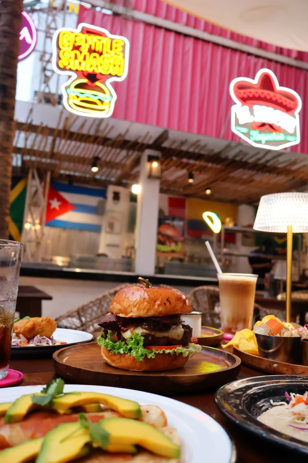 A table at Onda Lounge under the neon signs of the kitchens