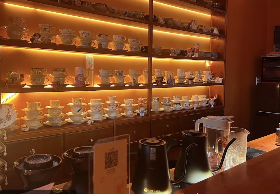 A backlit wall of handmade cups and pour over kettles at SẾU the tearoom