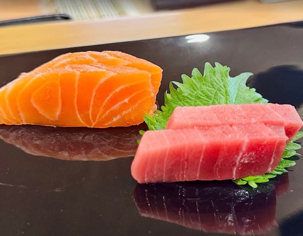 Sushi Seki, những lát sashimi cá hồi và cá ngừ bên lá tía tô Nhật trên đĩa đen