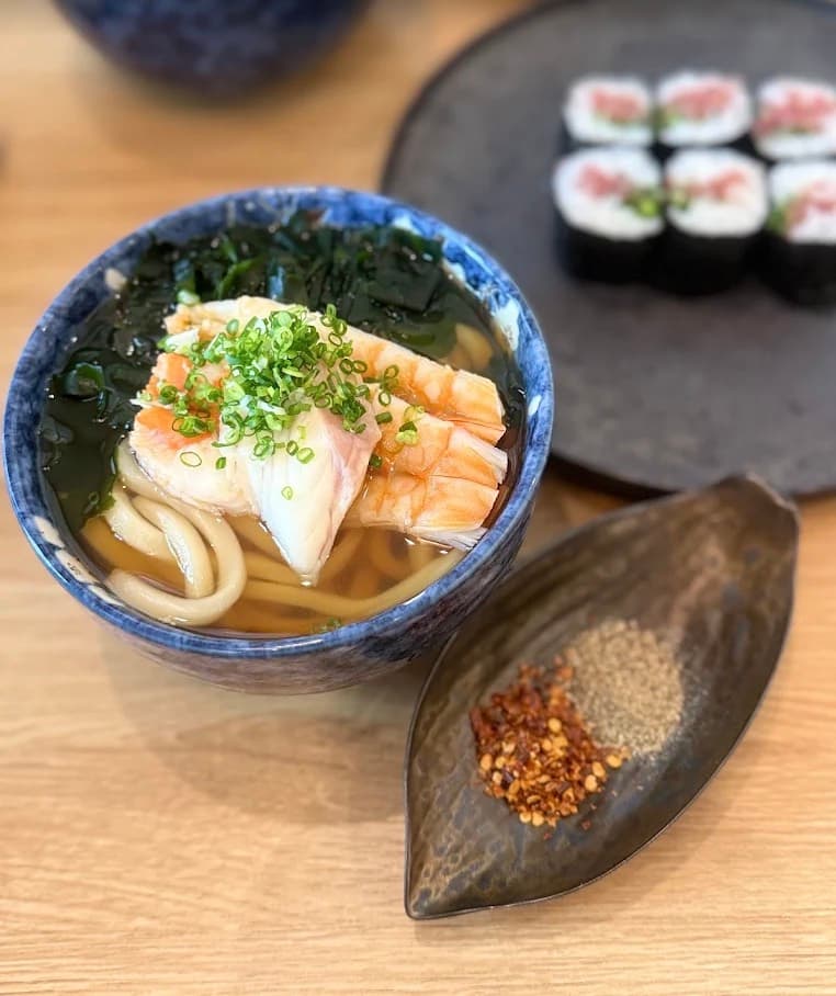 Sushi Seki, tô mì udon với hải sản, rong biển và hành lá, phía sau là đĩa sushi cuộn