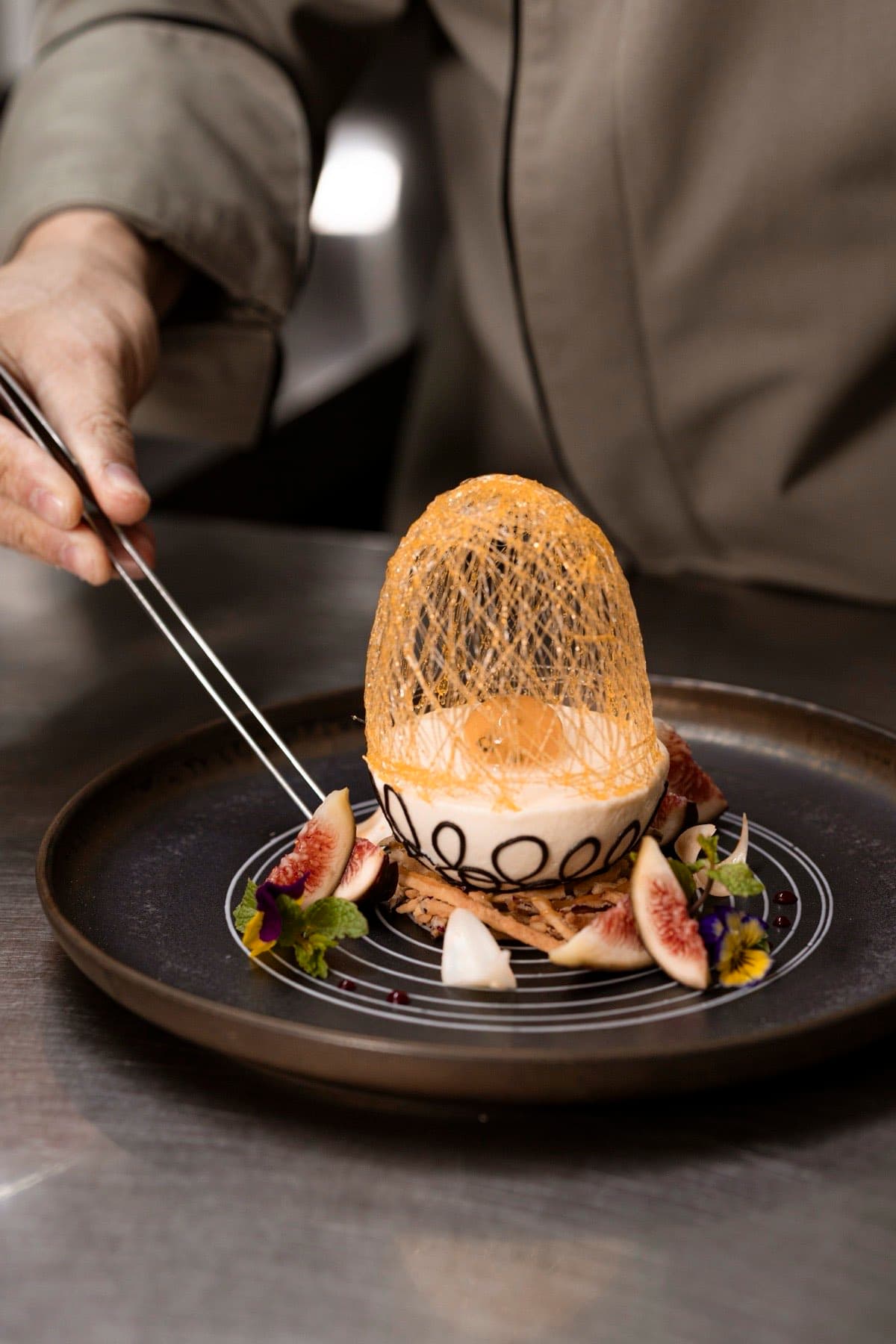 The Temptation, bếp trưởng dùng nhíp đặt lớp vỏ đường kéo sợi lên món tráng miệng