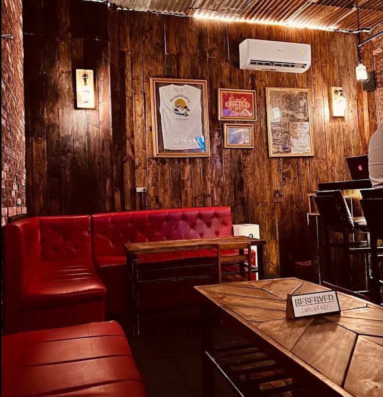 Red leather banquettes and wood panelling inside United Bar, with a reserved card on one of the tables