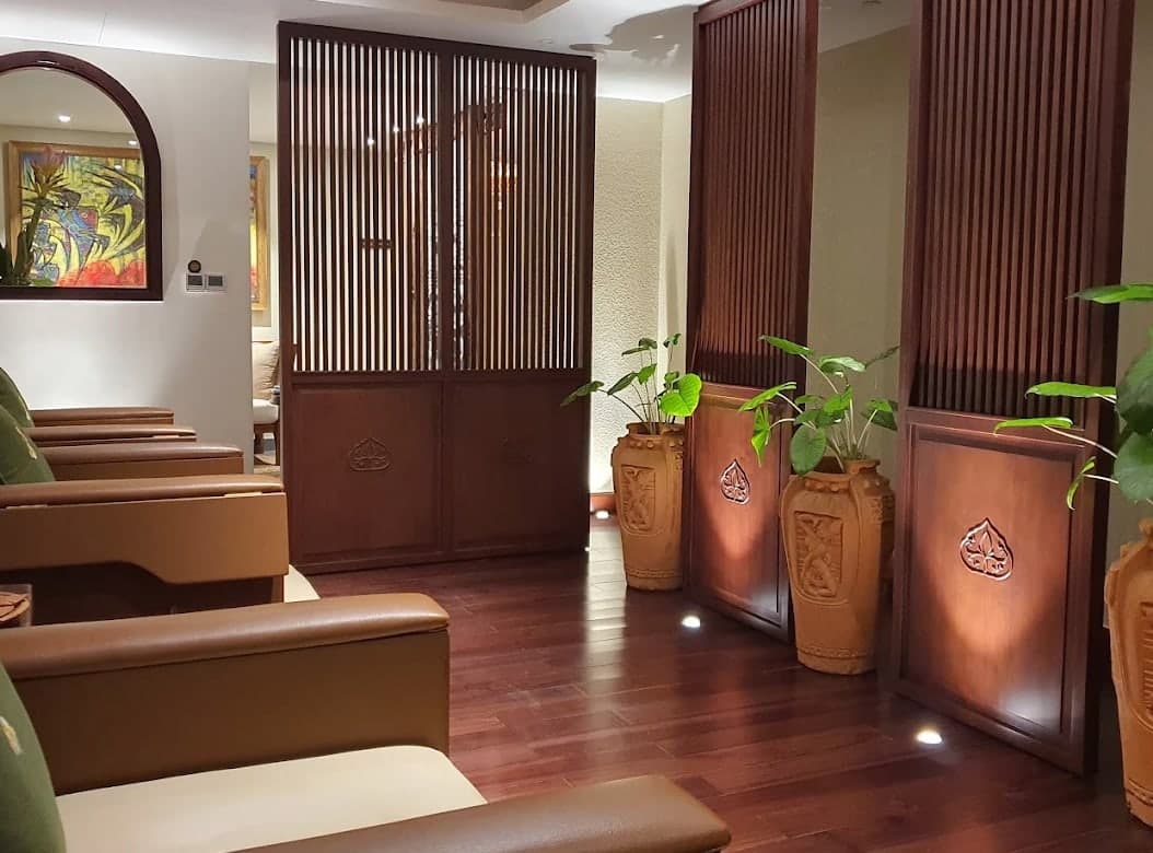 A lounge of reclining chairs at V-Senses Wellness & Spa, with carved wooden screens and clay jars