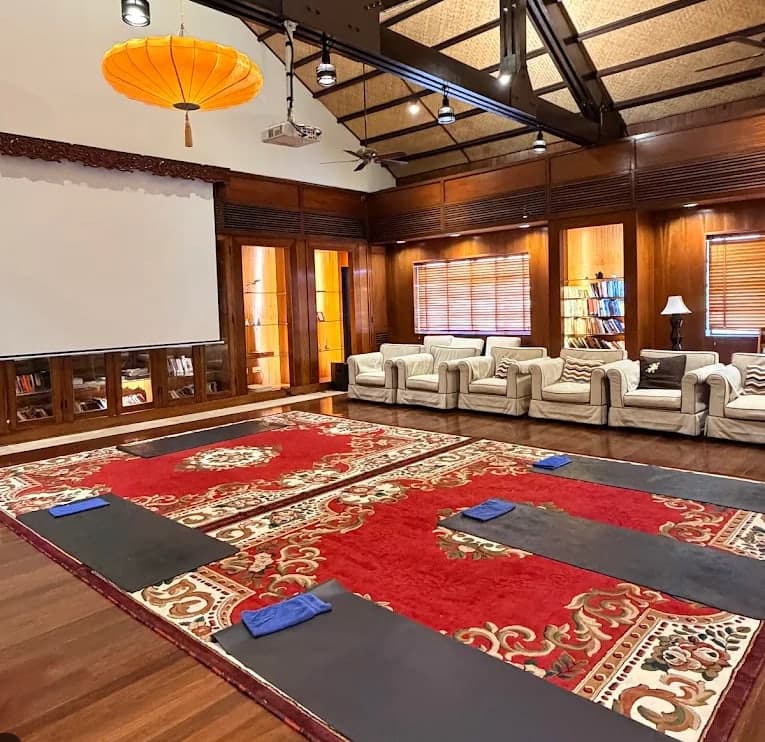 Yoga mats and towels laid on a red carpet in a wood room at V-Senses Wellness & Spa