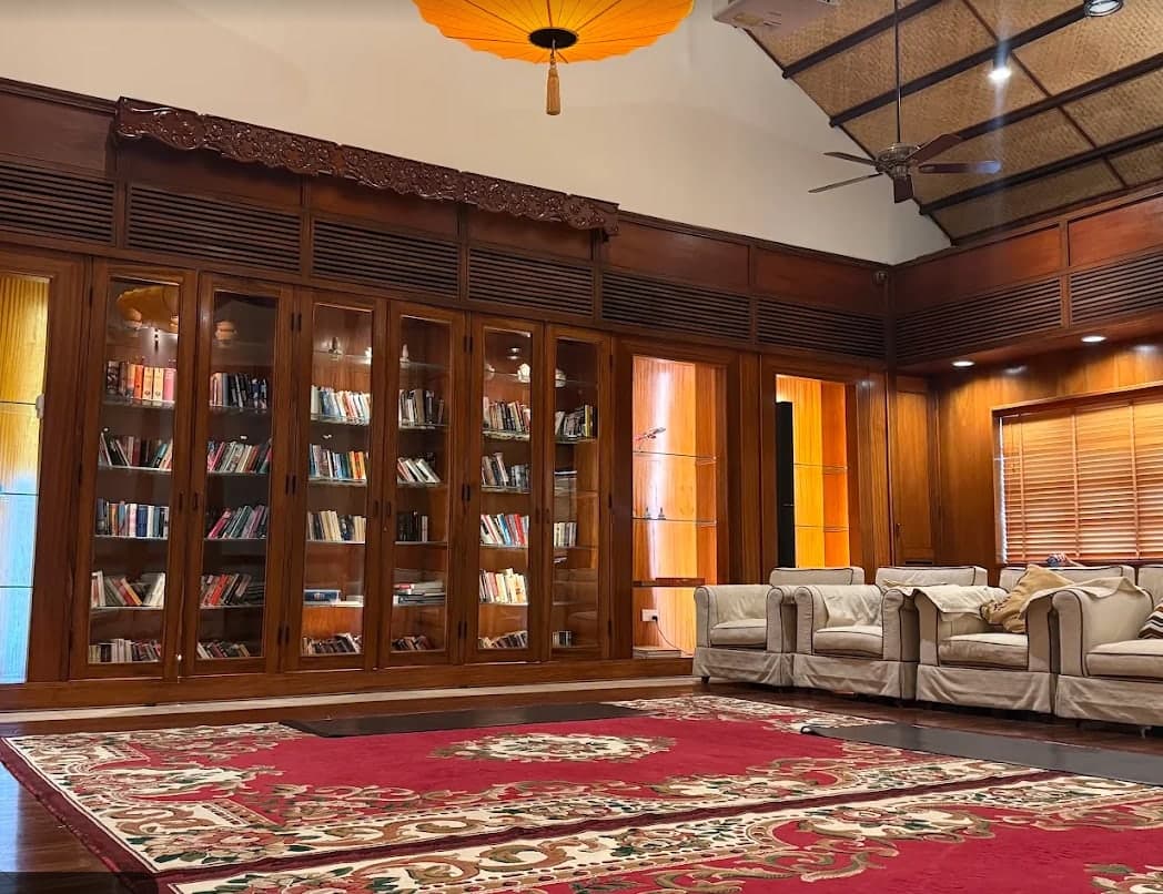 A room at V-Senses Wellness & Spa with glass book cases, armchairs and a red carpet