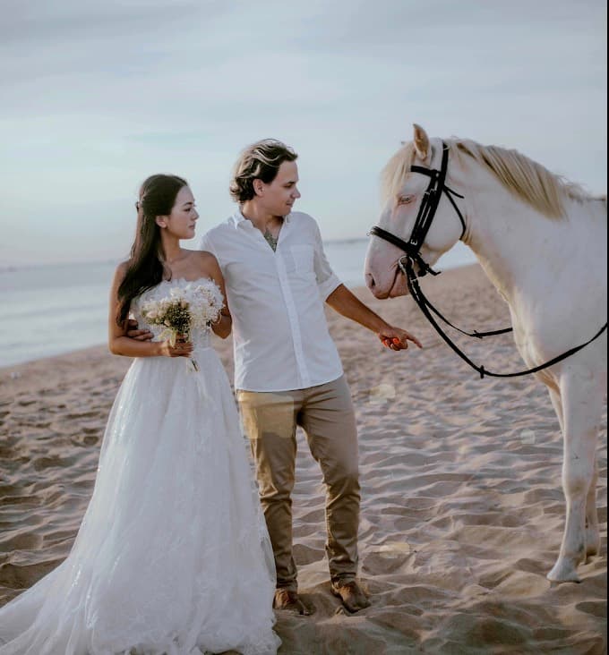 Vietnam Equestrian Club, a couple in wedding clothes on the beach beside a white horse